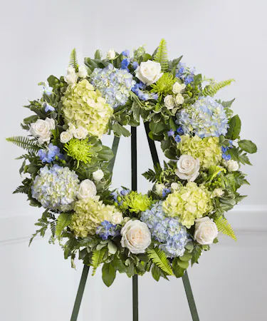 Blue and White Garden Floral Wreath on a standing easel featuring hydrangea, roses, delphinium and lush foliage