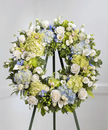 Blue and White Garden Floral Wreath on a standing easel featuring hydrangea, roses, delphinium and lush foliage