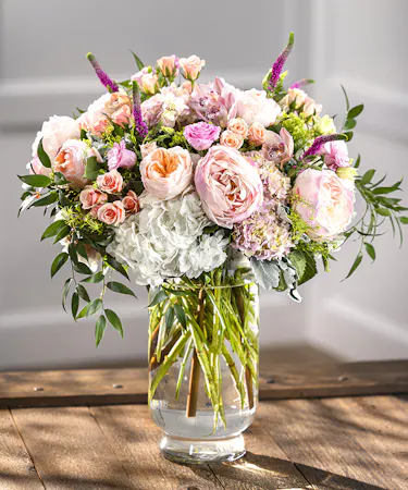 Grand Splendor Vase Arrangement featuring peonies, roses, hydrangea and favorite garden flowers in a tall pedestal vase.