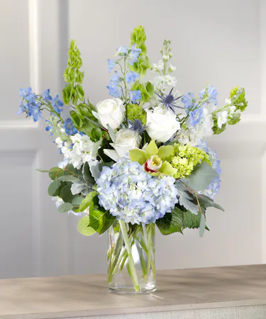 Summer Skies featuring blue hydrangea, roses, stock, bells of Ireland and orchids