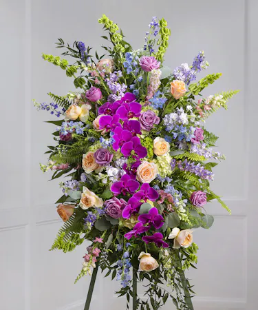 Pastel Garden Standing Sympathy Spray featuring kiwi hydrangea, mountain roses, larkspur, delphinium on a standing easel