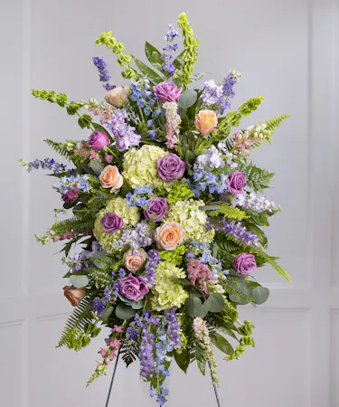Pastel Garden Standing Sympathy Spray featuring kiwi hydrangea, mountain roses, larkspur, delphinium on a standing easel