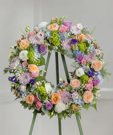 Elegant Pastel Garden Sympathy Wreath featuring pastel farm-fresh flowers on a standing easel