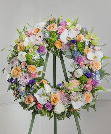 Elegant Pastel Garden Sympathy Wreath featuring pastel farm-fresh flowers on a standing easel