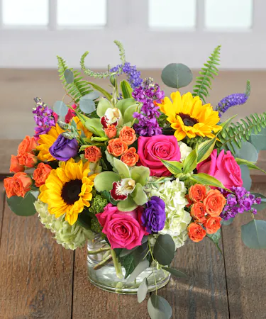 The Brilliance Bouquet featuring hydrangea, Garden Roses, Sunflowers & Orchids.
