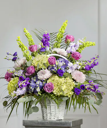 Purple and Lavender Floral Garden Sympathy Basket featuring purple hydrangea, roses, bells of Ireland and seasonal foliage