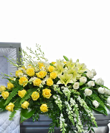 Yellow and White Garden Casket Spray by Carithers Flowers featuring lilies, hydrangea, roses, and seasonal garden spring garden flowers